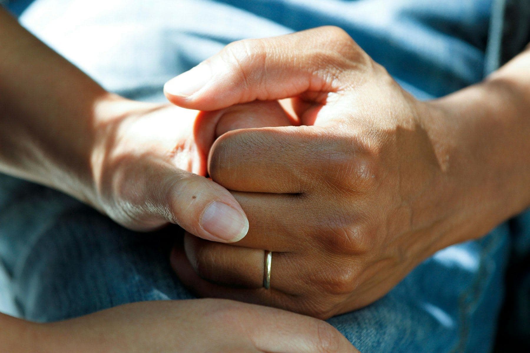 Two people holding hands reassuringly